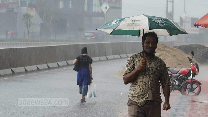 A man carries an umbrella on his way around the capital amid intermittent rain on Sunday, May 19, 2023. Photo: Asif Mahmud Ove