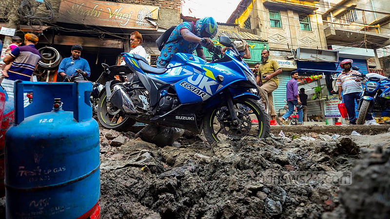 A motorcycle gets stuck in the mud while passing through Kazi Alauddin Road in Old Dhaka as the path is riddled with holes amid ongoing sewage repair works. Photo: Mahmud Zaman Ovi