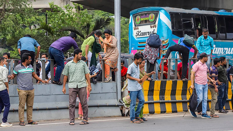 Many candidates for bank jobs scale a traffic median in the MES area to cross the busy Airport Road in Dhaka after the recruitment tests on Friday, Mar 31, 2023. Photo: Tawhiduzzaman Tapu