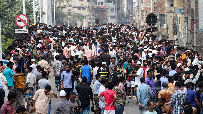 A crowd gathers at Dhaka’s Bangabazar after a horrendous fire guts shops at a vital clothing market on Tuesday, Apr 4, 2023. Photo: Asif Mahmud Ove