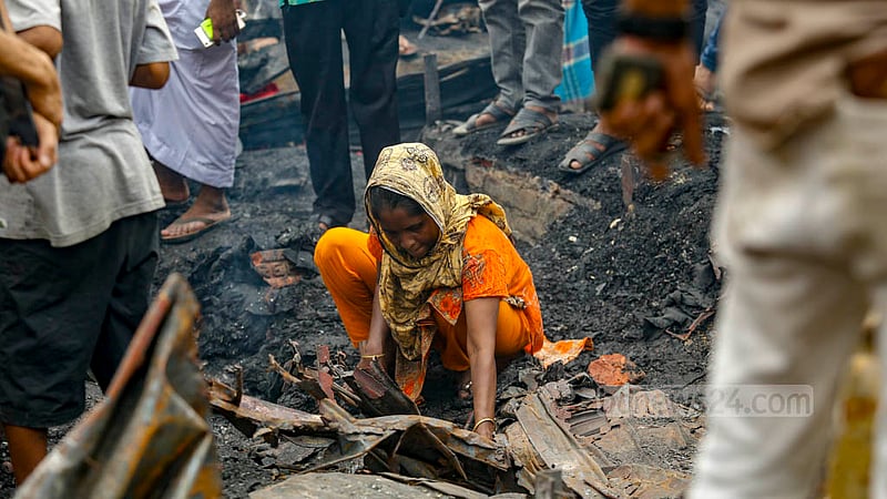 Women take burnt tin from the debris of a store at Bangabazar market. Photo: Mahmud Zaman Ovi
