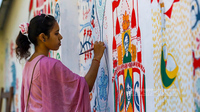 A student of Dhaka University’s Faculty of Fine Arts draws motifs on a paper fan to be sold at their stalls at the entrance of their faculty premises during the Bangla New Year festival. Photo: Mahmud Zaman Ovi