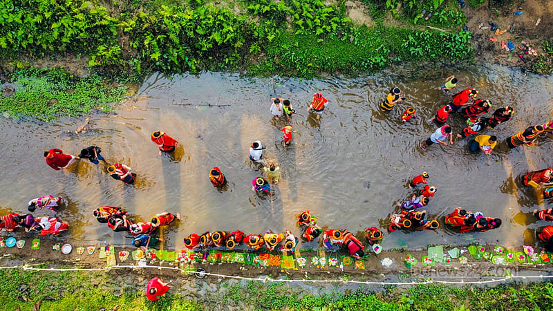 Tripura women offer new hand-woven cloth to Goddess Ganga near a hillside waterfall in Khagrachhari's Khagrapur area, praying for improved weaving skills. Photo: Samir Mallik