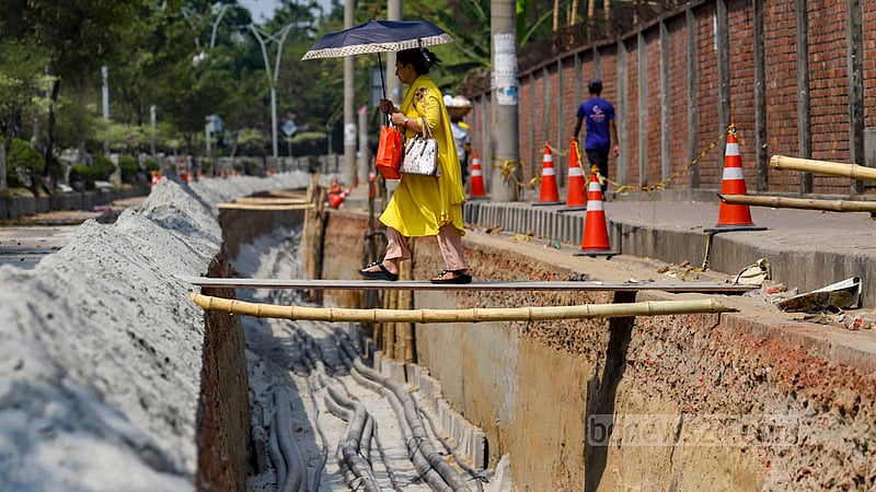 Parts of Hatirjheel Link Road in Dhaka are being dug up for the installation of DPDC cables. People have to cross the hole on wood boards in Moghbazar’s Ambagan and Noyatola.