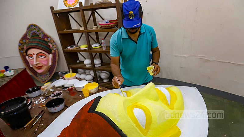 A student of Dhaka University’s Faculty of Fine Arts paints a mask on Thursday, Apr 13, 2023, as they prepare for the procession to celebrate Bangla New Year. Photo: Mahmud Zaman Ovi