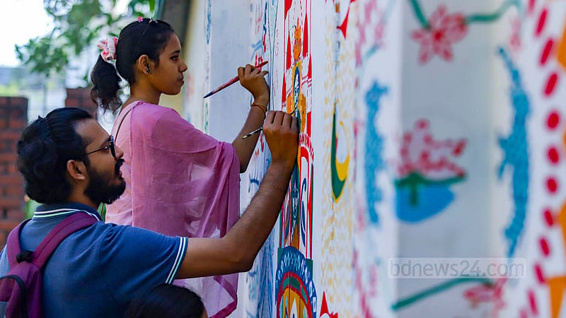 A student of Dhaka University’s Faculty of Fine Arts draws motifs on a paper fan to be sold at their stalls at the entrance of their faculty premises during the Bangla New Year festival. Photo: Mahmud Zaman Ovi