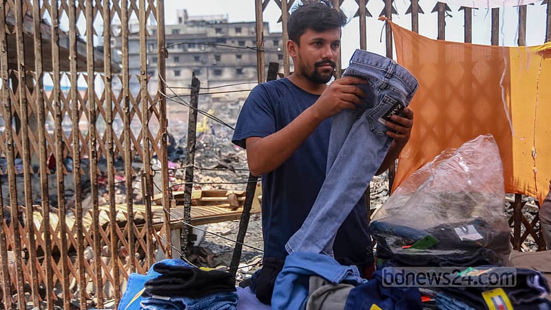 A trader sells dresses outside the burnt-down Bangabazar market. Photo: Tawhiduzzaman Tapu