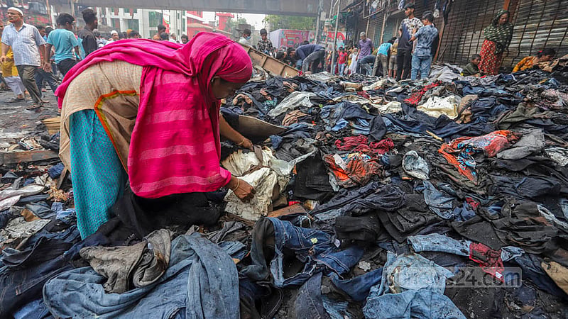 Women carry off some burnt and half-burnt clothing from the debris of Dhaka’s Bangabazar market. Photo: Asif Mahmud Ove