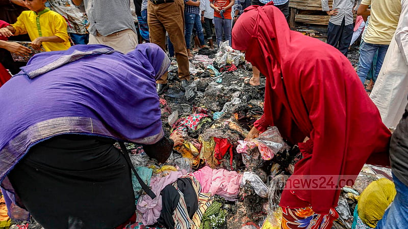 Women carry off some burnt and half-burnt clothing from the debris of Dhaka’s Bangabazar market. Photo: Mahmud Zaman Ovi