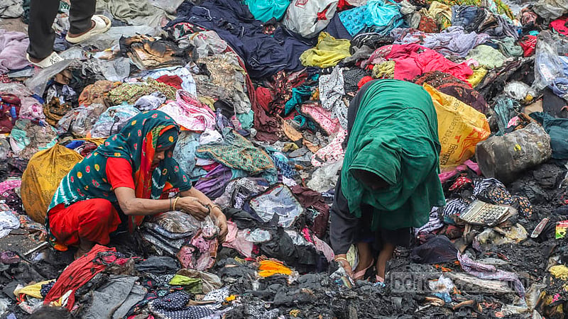 Women carry off some burnt and half-burnt clothing from the debris of Dhaka’s Bangabazar market. Photo: Asif Mahmud Ove