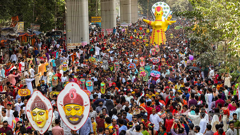 People of all ages adorned in Baishakhi clothes and masks in hand join the Mangal Shobhajatra procession and dance to drum beats to celebrate Pahela Baishakh in Dhaka on Friday, Apr 14, 2023. Photo: Mahmud Zaman Ovi