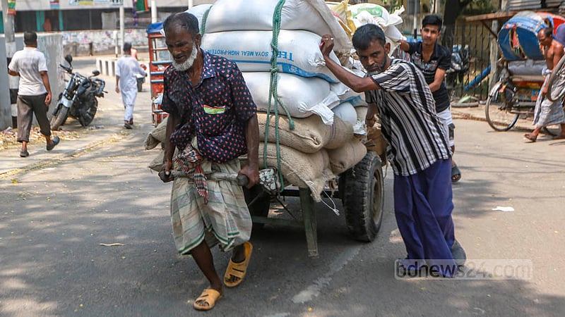 Workers transport goods in wheelbarrows at Beribadh in Dhaka's Kamrangirchar amid extreme heat on Monday, Apr 17, 2023. Photo: Tawhiduzzaman Tapu