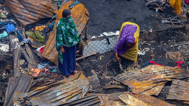 Women take burnt tin from the debris of a store at Bangabazar market. Photo: Mahmud Zaman Ovi