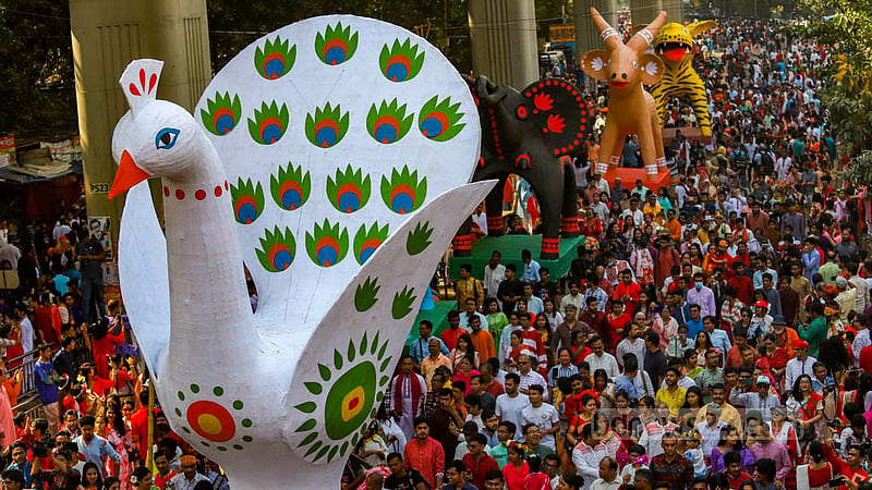 People of all ages adorned in Baishakhi clothes and masks in hand join the Mangal Shobhajatra procession and dance to drum beats to celebrate Pahela Baishakh in Dhaka on Friday, Apr 14, 2023. Photo: Mahmud Zaman Ovi