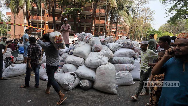 Traders evacuate their goods from their shops after a huge fire breaks out in Dhaka’s Bangabazar on Tuesday, Apr 4, 2023. Photo: Asif Mahmud Ove