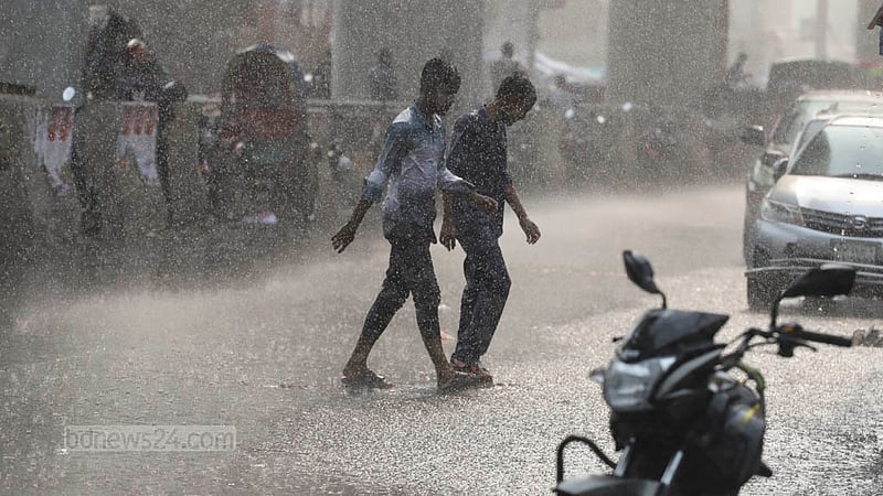 People walk through the rains at Paltan in Dhaka after days of scorching heat on Saturday, May 6, 2023. Photo: Asif Mahmud Ove