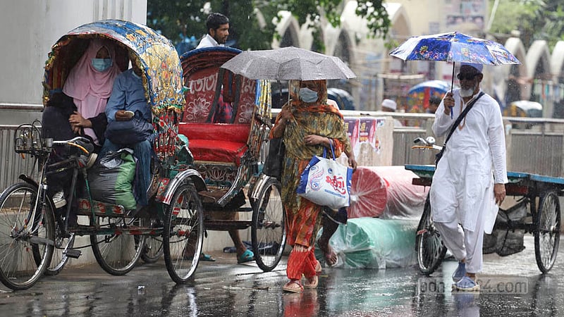 People use umbrellas amid rains in Dhaka on Saturday, May 6, 2023.  Photo: Asif Mahmud Ove