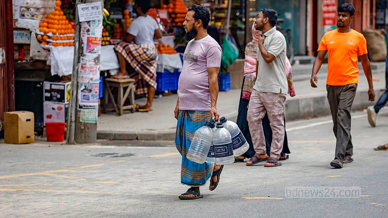 A man carries an empty bottle to the WASA ATM booth to collect drinking water in Dhaka’s Banasree. Photo: Mahmud Zaman Ovi