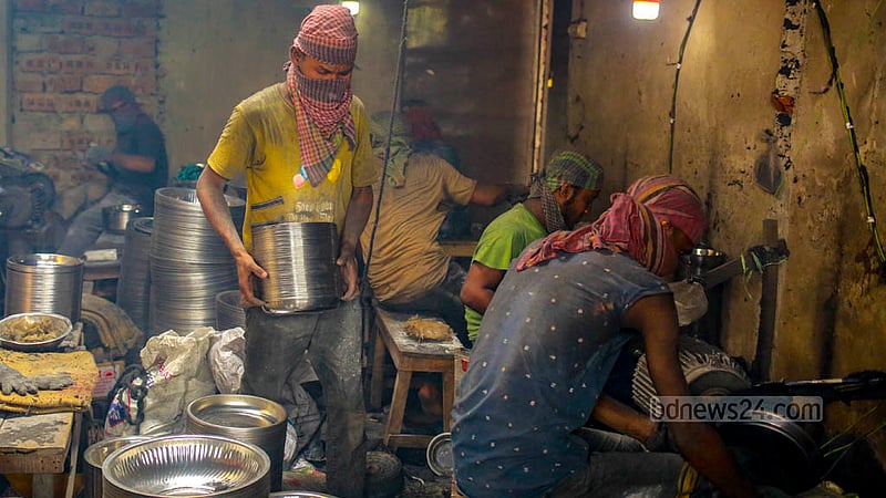 A worker takes out utensils after polishing is completed at a factory in Kamrangirchar on Friday, May 26, 2023. Photo: Tawhiduzzaman Tapu