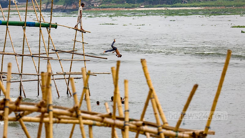 A group of children leap into the Buriganga River in the Munshikhola area of Dhaka's Shyampur to escape the heat. Photo: Mahmud Zaman Ovi