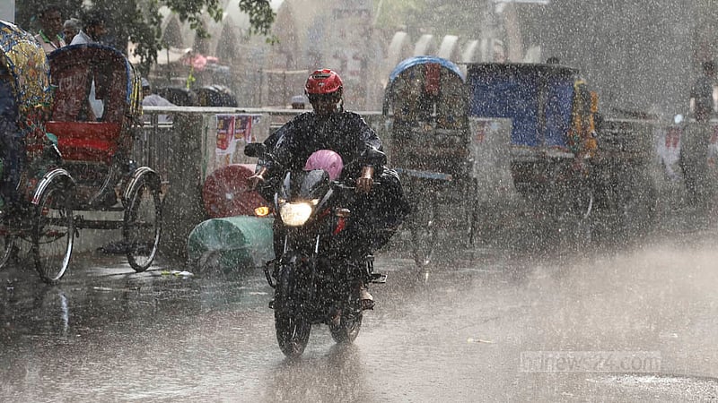 A man rides a motorcycle through the rain at Paltan in Dhaka after days of scorching heat on Saturday, May 6, 2023. Photo: Asif Mahmud Ove