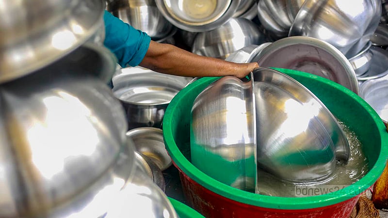 A female worker cleans utensils on Friday, May 26, 2023 made in an aluminium factory in Dhaka’s Kamrangirchar. Photo: Tawhiduzzaman Tapu