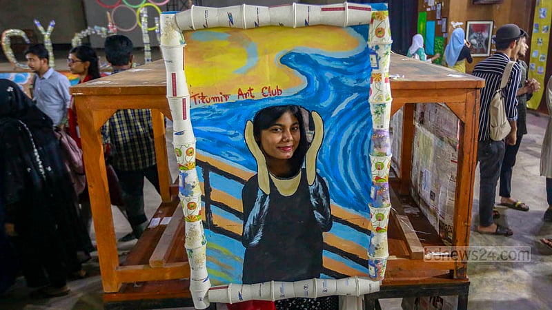 A student takes pictures of tea cups and pots made out of papers in an exhibition organised by the Titumir Art Club at the Shaheed Barkat Auditorium on Monday, May 29, 2023. Photo: Tawhiduzzaman Tapu