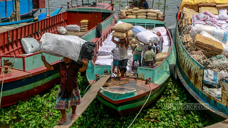Workers are busy unloading goods from a boat amidst the scorching afternoon heat in Dhaka’s Swarighat area on Tuesday, Jun 6, 2023. Photo: Tawhiduzzaman Tapu