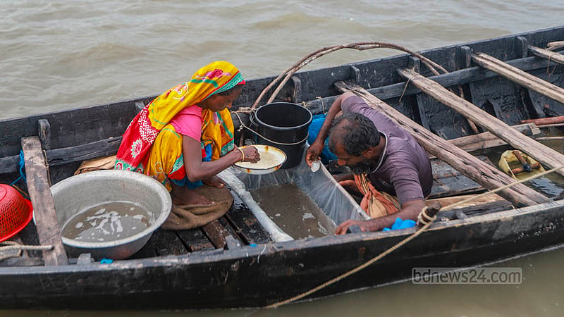 Mohammad Kamal and Nasima Begum sort out fish fries collected from the Sutarkhali river in Khulna’s Dakop Upazila. Photo: Tawhiduzzaman Tapu