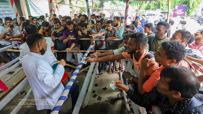 Passengers buy standing tickets from a travelling ticket examiner at Airport Railway Station in Dhaka on Tuesday, Jun 27, 2023, before Eid-ul-Azha. Photo: Asif Mahmud Ove