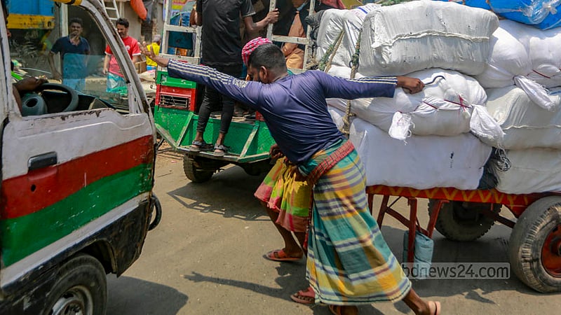 In the blazing afternoon sun, workers in Dhaka’s Swarighat area load push carts with goods and depart for their destination on Tuesday, Jun 6, 2023. Photo: Tawhiduzzaman Tapu