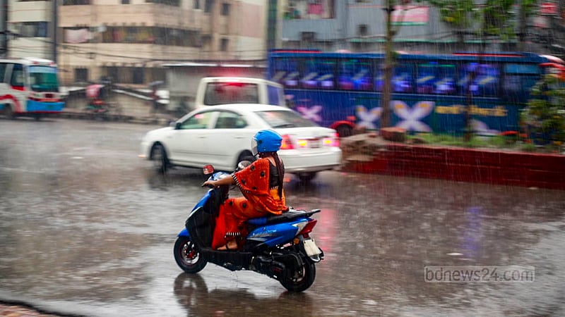 A woman drives a motorcycle through rains in Dhaka on Friday, Jun 9, 2023, after days of an intense heatwave worsened by frequent power cuts. Photo: Tawhiduzzaman Tapu