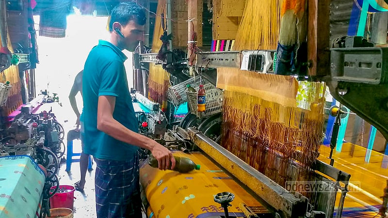 Weavers continue their work amid frequent power cuts at Tantpalli in Tangail but the high demand of Sarees ahead of Eid looks impossible to meet.