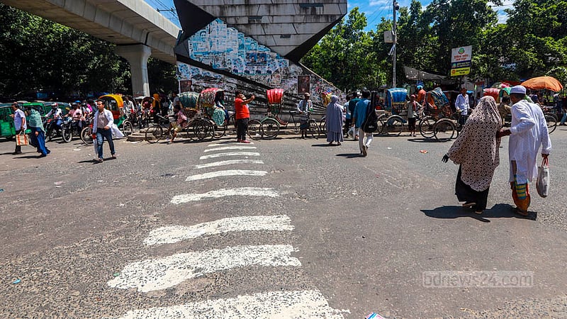 Pedestrians ignore traffic rules by not using the zebra crossing at the Shahbagh intersection in Dhaka.