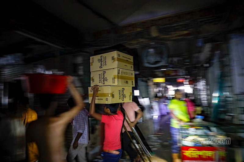 Some shop owners and their associates at Gulshan Shopping Centre are spotted moving their products in the dark on Sunday, Jul 16, 2023, as authorities shut down power lines to the mall. Photo: Mahmud Zaman Ovi