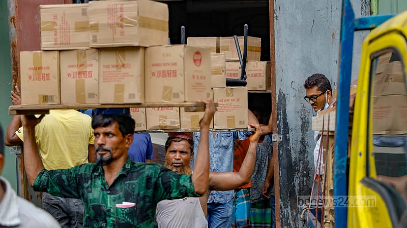 Gulshan Shopping Centre shop owners and their associates move their products from the shopping mall building on Sunday, Jul 16, 2023, as authorities will soon demolish the ‘risky’ establishment. Photo: Mahmud Zaman Ovi
