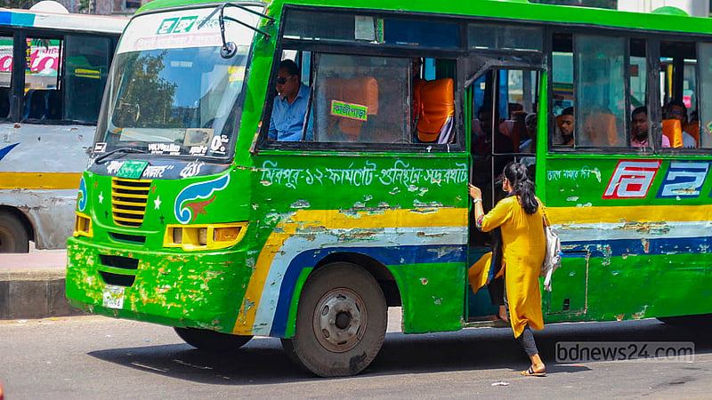 A woman risks boarding a moving bus at the Farmgate intersection in Dhaka on Thursday, Jul 20, 2023. Photo: Tawhiduzzaman Tapu