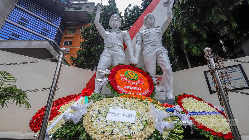 The mural of the two police officers killed in the 2016 terrorist attack at Dhaka's Holey Artisan Bakery is covered with flowers. Photo: Asif Mahmud Ove