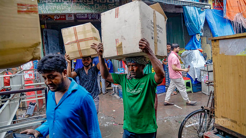 Gulshan Shopping Centre shop owners and their associates move their products from the shopping mall building on Sunday, Jul 16, 2023, as authorities will soon demolish the ‘risky’ establishment. Photo: Mahmud Zaman Ovi