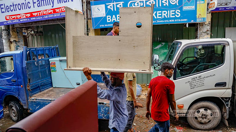 Some shop owners and their associates at Gulshan Shopping Centre are spotted moving their products in the dark on Sunday, Jul 16, 2023, as authorities shut down power lines to the mall. Photo: Mahmud Zaman Ovi