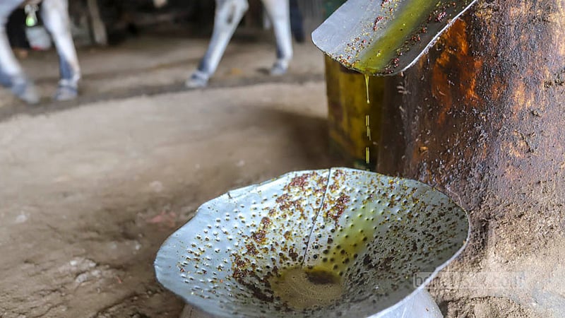 Mustard oil drips from the pipeline of Ghani, a traditional wooden oil mill. Mustard is brought from different places around the country. Photo: Asif Mahmud Ove