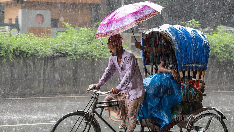A passenger holds out his umbrella to give his rickshaw driver some relief from the rain in Dhaka’s Mirpur on Wednesday, Jun 26, 2023. Photo: Asif Mahmud Ove