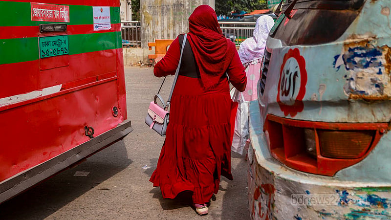 Two women are seen crossing the road in front of a moving bus at the Shahbagh intersection in Dhaka on Saturday, Aug 26, 2023. Photo: Tawhiduzzaman Tapu
