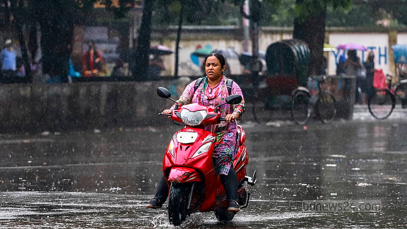 A woman rides a scooter through rain in the TSC area of Dhaka University on Thursday, Aug 24, 2023. Photo: Tawhiduzzaman Tapu