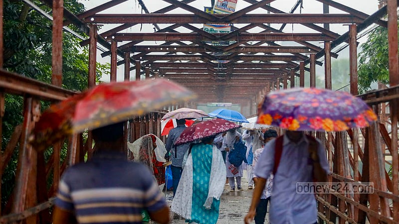 People carrying colourful umbrellas traverse the footbridge at Dhaka’s Kamalapur amid the rain on Wednesday, Aug 16, 2023. Photo: Mahmud Zaman Ovi
