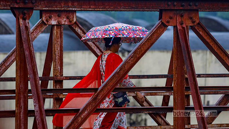 A woman gracefully clutches a colourful umbrella amidst the torrential rain in Dhaka on Wednesday, August 16, 2023. Photo: Mahmud Zaman Ovi