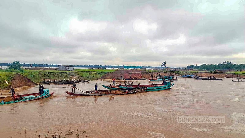 Trawlers stand by to transport the sand and stone mined from Sunamganj’s Tahirpur on the banks of the Jadukata River. The extraction occurs every day.