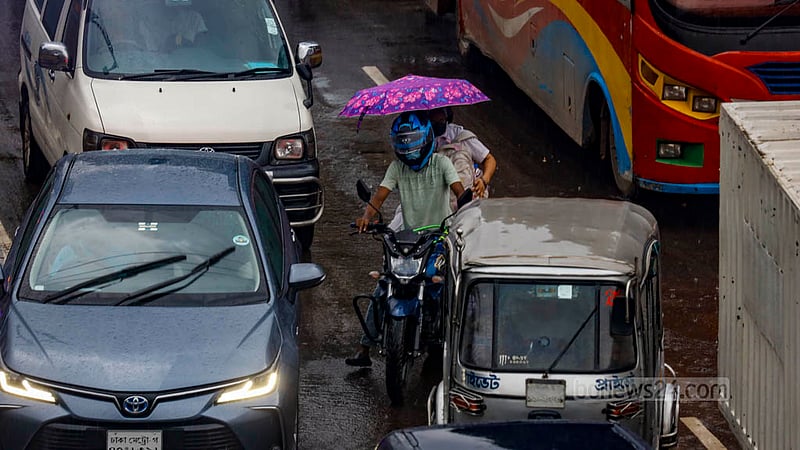A pillion rider uses an umbrella as the motorcyclist drives through rain in Dhaka’s Tejgaon on Thursday, Aug 10, 2023. Photo: Mahmud Zaman Ovi