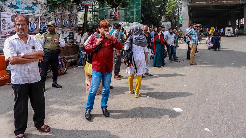 Commuters patiently wait for the arrival of a bus at the Shahbagh intersection in Dhaka on Saturday, Aug 26, 2023. Photo: Tawhiduzzaman Tapu