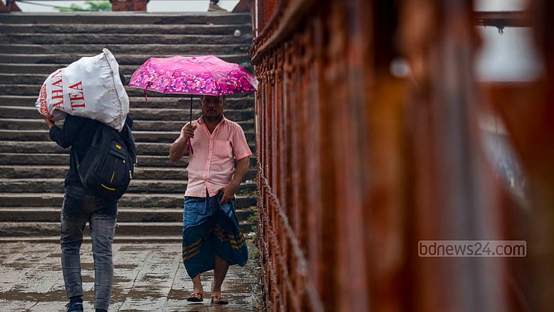 An individual holding a colourful umbrella crosses the footbridge at Dhaka’s Kamalapur in the midst of rain on Wednesday, Aug 16, 2023. Photo: Mahmud Zaman Ovi
